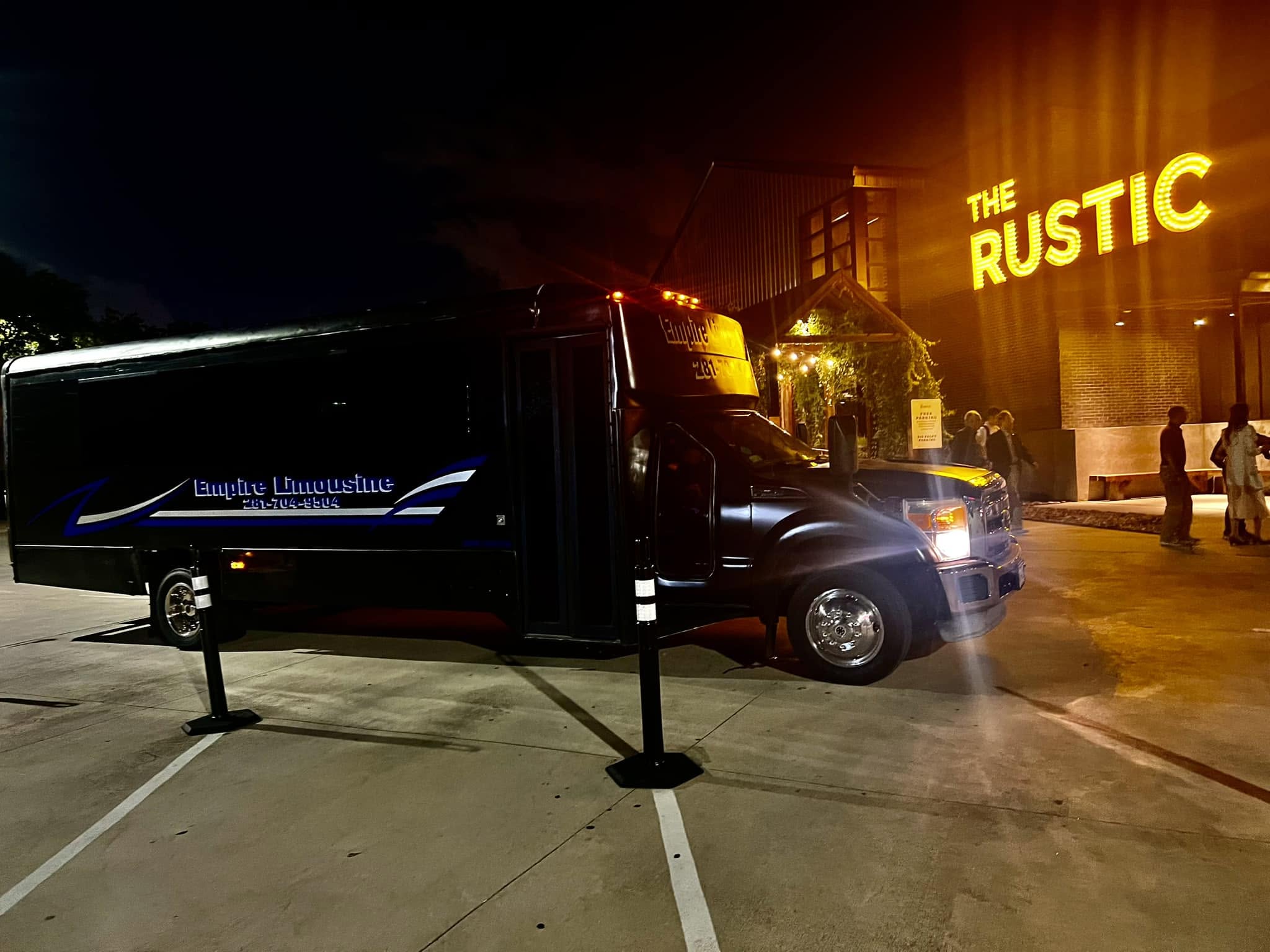 Empire Limousine party bus arriving at The Rustic at night